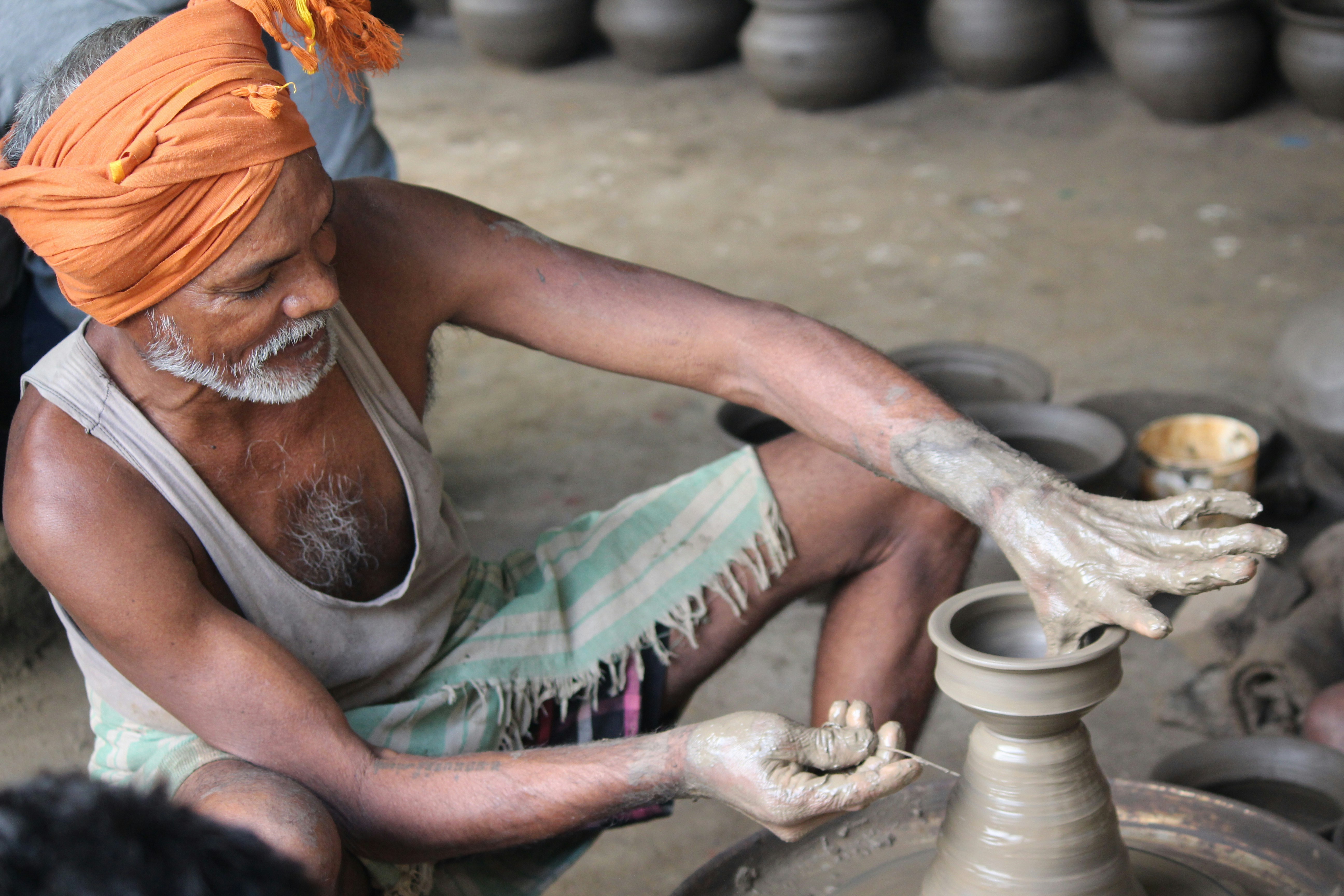An artisan shaping clay on a pottery wheel with skillful hands.